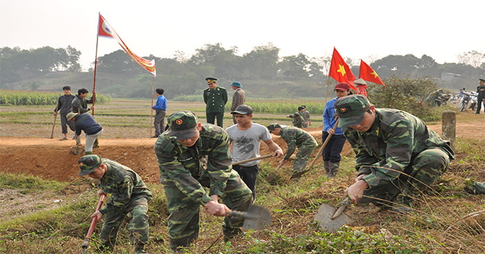 Các chiến sĩ bộ đội làm công tác dân vận, giúp dân làm đường.