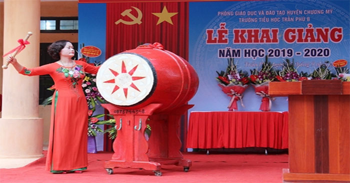 Hình ảnh minh họa cô hiệu trưởng đánh trống khai giảng
